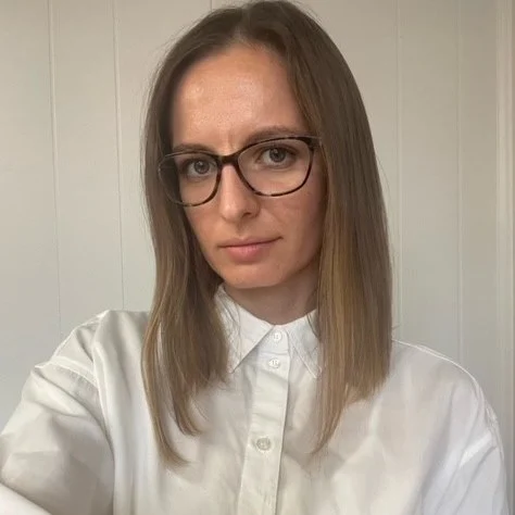2_101554_21992639 A woman with glasses and long hair wearing a white shirt.